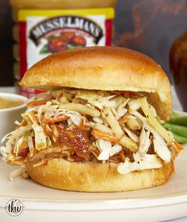 Adding BBQ pulled chicken topped with a lip-smacking applesauce BBQ sauce and crispy apple coleslaw to a soft brioche bun for one of the most amazing BBQ chicken sandwiches you’ll ever eat! The Most Amazing Pulled Chicken Sandwich with Crisp Apple Coleslaw, applesauce bbq sauce, apple coleslaw, appleslaw, apple bbq sauce, apple sauce bbq sauce, football food, tailgating, shredded chicken, bbq pulled chicken