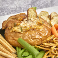 This cheesy smoked bread bowl is perfect for Sunday football or hanging out with friends. Stuffed with BBQ chicken, crispy bacon, cheese, and ranch seasoning, this over-the-top bread bowl is always a crowd favorite! Ultimate Smoked BBQ Chicken Bacon And Ranch Bread Bowl, stuffed bread bowl, crack chicken dip, bacon chicken ranch dip, smoked bread, yoder smokers, flattop grills