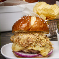 Prepare to take your taste buds on a flavor-packed journey of a perfectly grilled bratwurst burger stuffed with sauerkraut and gooey Swiss cheese. A slice of red onion, crispy sauerkraut, and whole-grain mustard on a pretzel bun will make this your new favorite burger! The Best Grilled German Bratwurst Burgers Stuffed With Cheese & Sauerkraut, grilled German bratwurst, juicy Lucy German burgers, Oktoberfest burgers, stuffed burgers, pork burgers, sausage burgers, grilled burgers