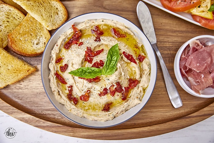 Made with rich ricotta cheese, fragrant Italian herbs, and flavorful sundried tomatoes, this dip is a symphony of flavors in every bite. Easy One Bowl Italian Herb Ricotta Dip with Sundried Tomatoes, one bowl dip, easy dip recipes, whipped ricotta, crostini toppers, bagel toppers, condiments, italian crostini, one bowl recipe