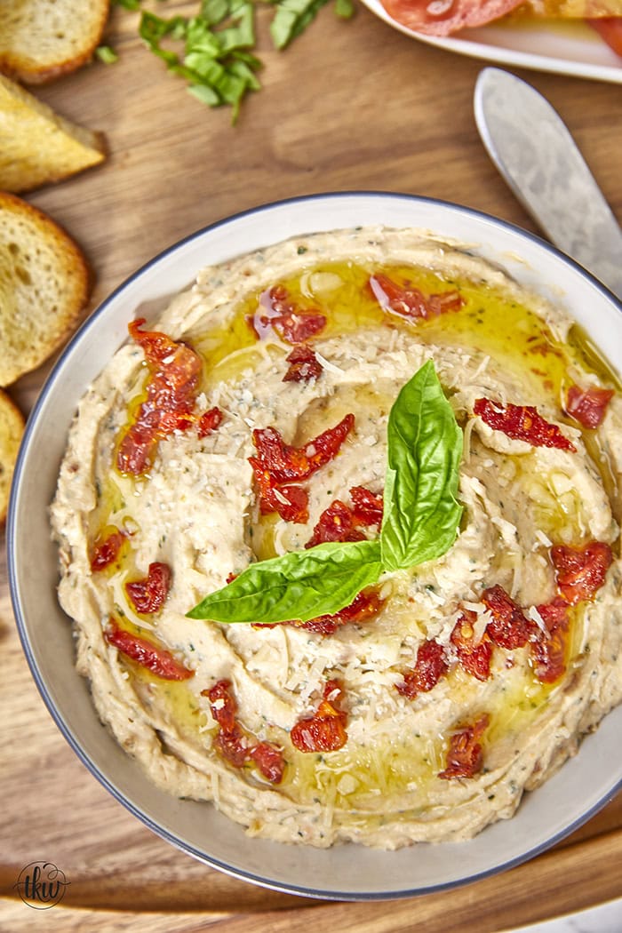 Made with rich ricotta cheese, fragrant Italian herbs, and flavorful sundried tomatoes, this dip is a symphony of flavors in every bite. Easy One Bowl Italian Herb Ricotta Dip with Sundried Tomatoes, one bowl dip, easy dip recipes, whipped ricotta, crostini toppers, bagel toppers, condiments, italian crostini, one bowl recipe