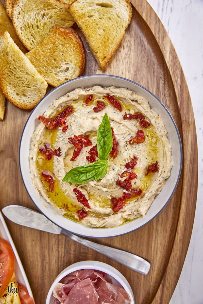 Made with rich ricotta cheese, fragrant Italian herbs, and flavorful sundried tomatoes, this dip is a symphony of flavors in every bite. Easy One Bowl Italian Herb Ricotta Dip with Sundried Tomatoes, one bowl dip, easy dip recipes, whipped ricotta, crostini toppers, bagel toppers, condiments, italian crostini, one bowl recipe