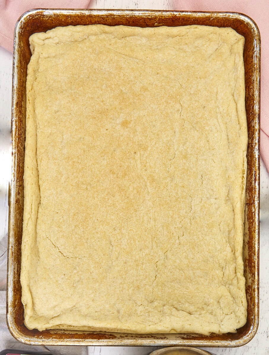 The very best soft vanilla sugar cookie crust that melts in your mouth, enhancing the flavors of your favorite fruit tarts and cookie pizzas. Easy Soft and Tender Vanilla Sugar Cookie Crust, pizza cookie, sheet pan cookie, fruit tarts, fruit pizzas, desserts for a crowd, sheet pan desserts, summer desserts, bar cookies