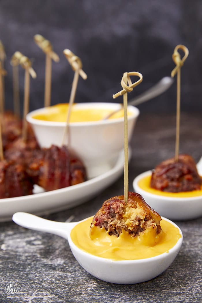 Tender, juicy meatballs oozing with cheesy goodness wrapped in seasoned bacon. It's time to fire up the smoker to make one of the best appetizers you'll ever eat! Bacon Wrapped Cheesy Big Mac Meatballs On The Smoker, cheesy meatballs, smoked meatballs, meatballs on the smoker, game day appetizers, meatballs stuffed with cheese