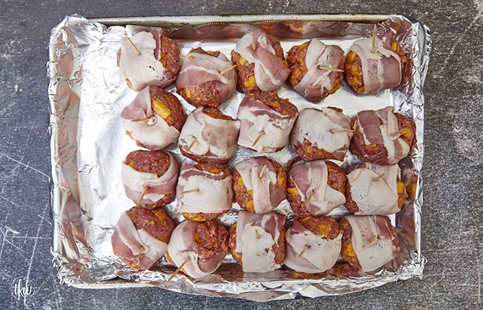 Tender, juicy meatballs oozing with cheesy goodness wrapped in seasoned bacon. It's time to fire up the smoker to make one of the best appetizers you'll ever eat! Bacon Wrapped Cheesy Big Mac Meatballs On The Smoker, cheesy meatballs, smoked meatballs, meatballs on the smoker, game day appetizers, meatballs stuffed with cheese