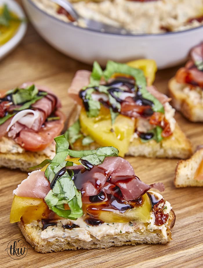 Truly a taste of Italy! Combining the richness of sundried tomatoes with the creamy goodness of whipped Italian herb ricotta, juicy heirloom tomatoes, prosciutto, basil ribbons, and a drizzle of balsamic glaze all atop crispy crostini to make the perfect Italian bite! Ultimate Heirloom Tomato Ricotta Prosciutto Italian Crostini, whipped Italian ricotta, easy summer appetizers, prosciutto crostini, no bake recipes, garden appetizers