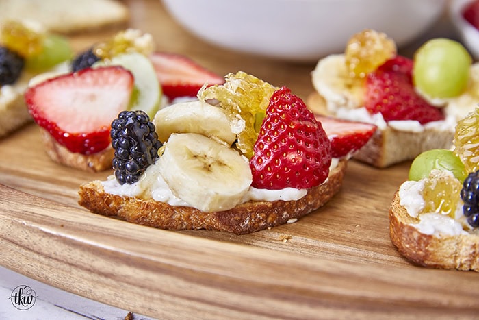 Honeycomb, whipped vanilla honey ricotta, and fresh fruits come together in a heavenly dessert crostini. This simple and sweet delight that will elevate any gathering or simply satisfy your sweet cravings. Simple Sweet Honeycomb Ricotta & Fresh Fruits Dessert Crostini, sweetened ricotta, ricotta spread, dessert ricotta, uses for leftover ricotta, bagel spread, crostini spread, cheesy dip, fruit dip, 3-ingredient ricotta dip