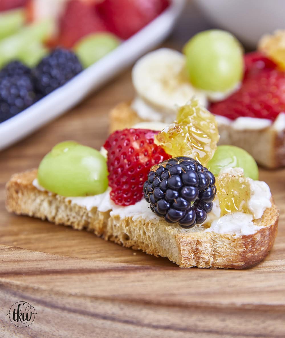 Honeycomb, whipped vanilla honey ricotta, and fresh fruits come together in a heavenly dessert crostini. This simple and sweet delight that will elevate any gathering or simply satisfy your sweet cravings. Simple Sweet Honeycomb Ricotta & Fresh Fruits Dessert Crostini, sweetened ricotta, ricotta spread, dessert ricotta, uses for leftover ricotta, bagel spread, crostini spread, cheesy dip, fruit dip, 3-ingredient ricotta dip