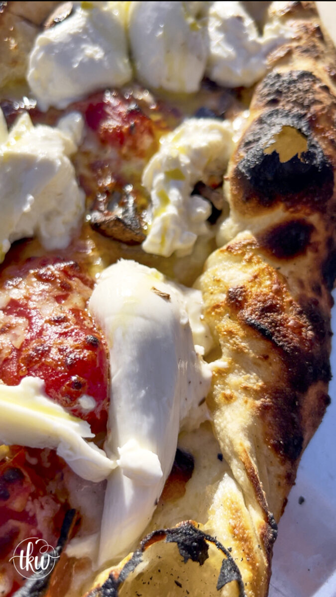 This wood-fired pizza, shaped like khachapuri, has a cheesy crust stuffed with cremini mushrooms, crispy bacon, and datterini tomatoes. It's then kissed with olive oil and finished with burrata, making it your new favorite pizza!