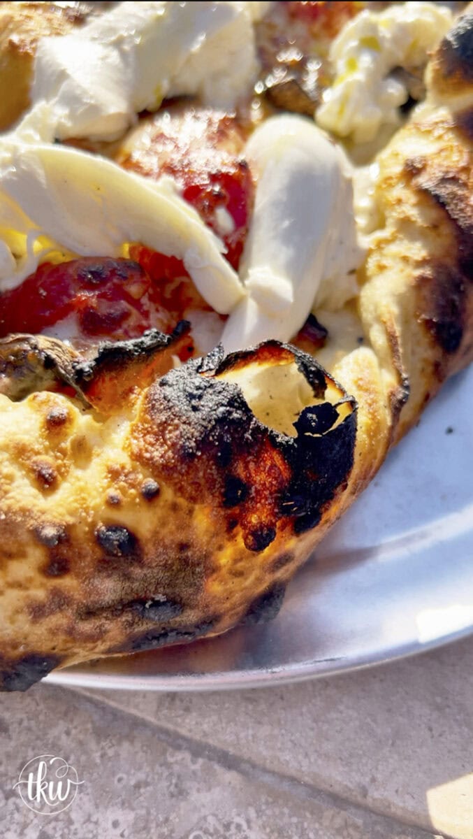 This wood-fired pizza, shaped like khachapuri, has a cheesy crust stuffed with cremini mushrooms, crispy bacon, and datterini tomatoes. It's then kissed with olive oil and finished with burrata, making it your new favorite pizza!